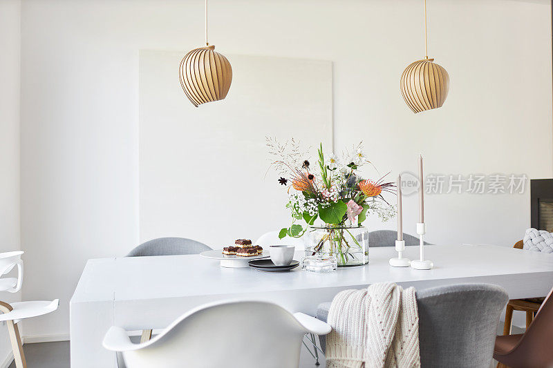 不同的照片装饰的白色餐桌在一个明亮的环境与鲜花和花瓶