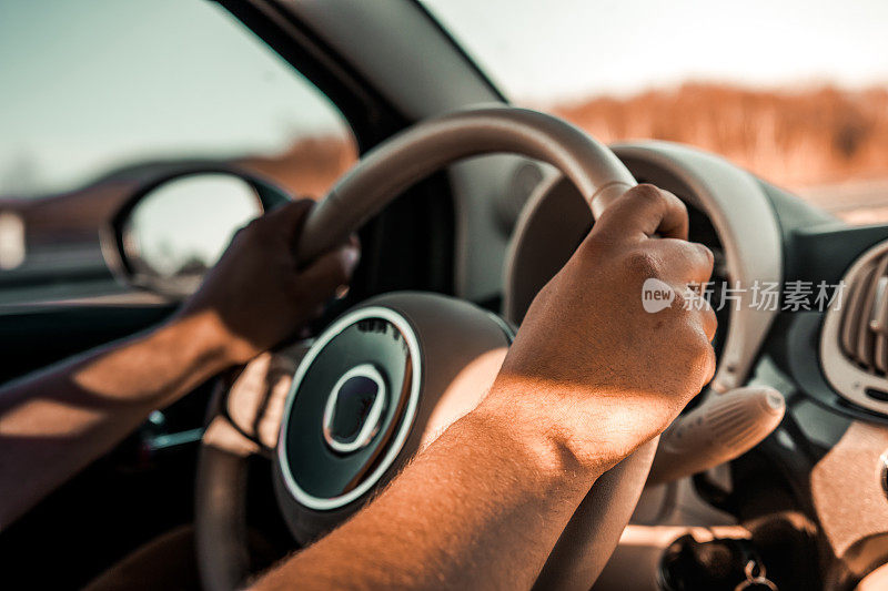 一名男子驾驶着一辆有或没有手机的汽车，握着方向盘