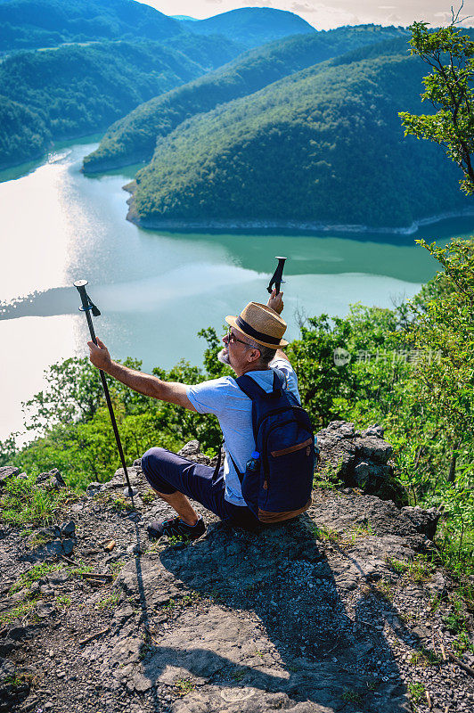 徒步旅行者坐在山顶欣赏风景