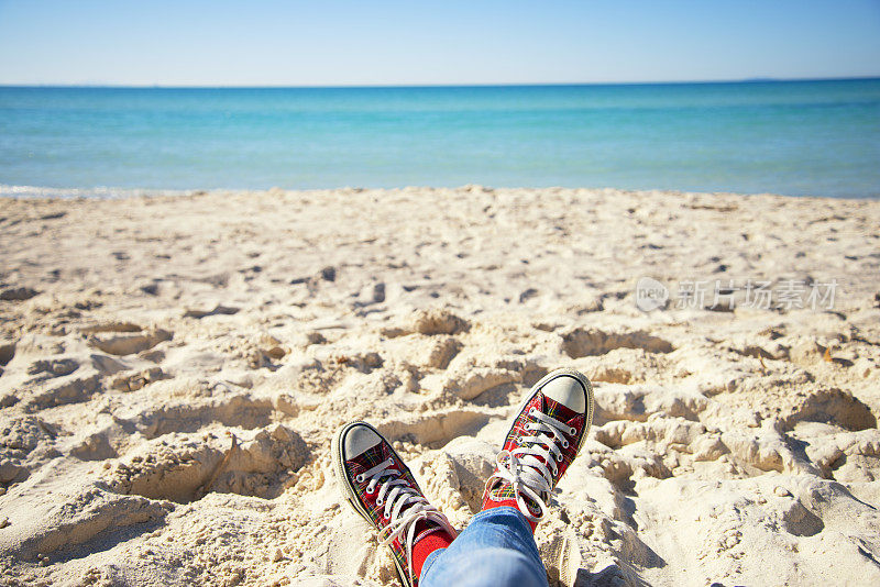 穿着鞋子在海边放松的女人