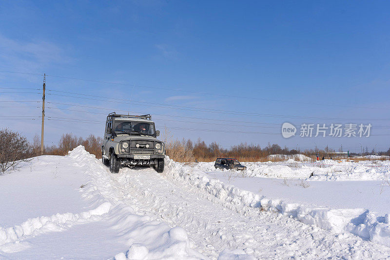 俄罗斯越野车“UAZ猎人469”4x4骑在雪山在一个冬天在一个坏的道路上的田野。