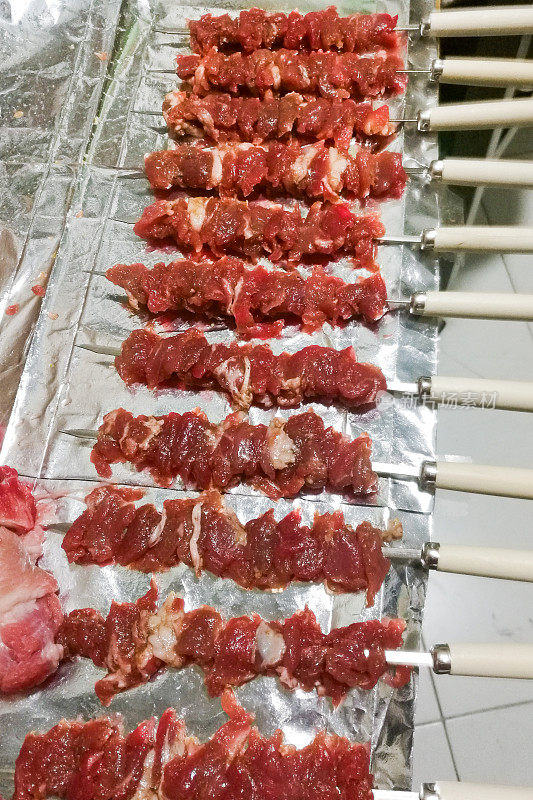 烤肉串。烧烤。中式烤肉，配上香料和蔬菜，以木板为背景