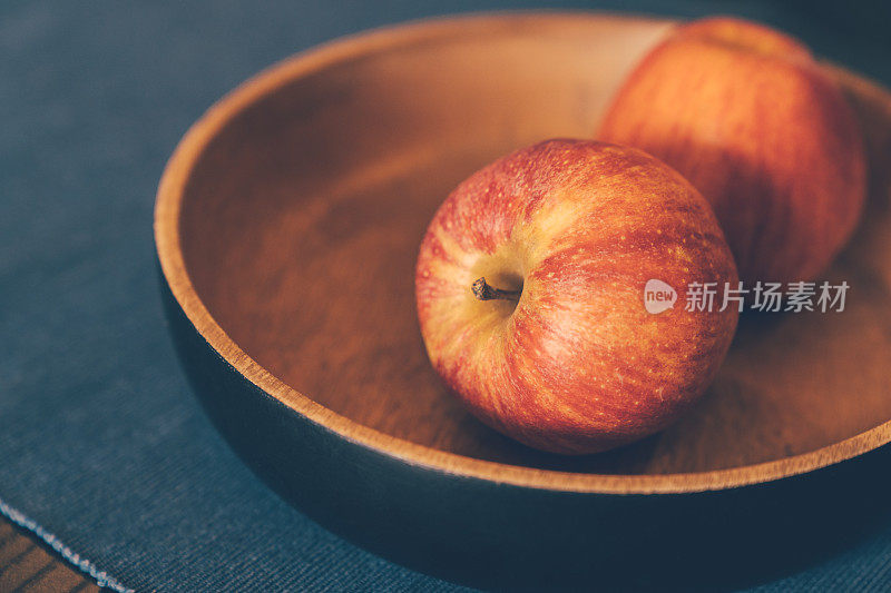 熟透的新鲜苹果放在木碗里。