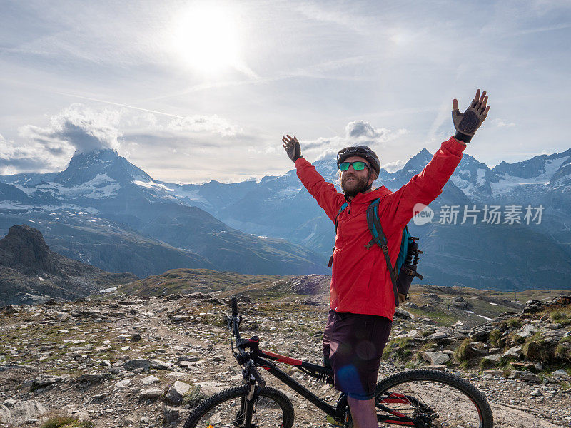 男性山地摩托车手拥抱自由，他伸出双臂