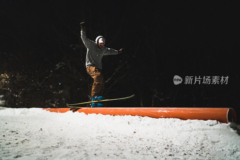 自由式滑雪者在城市公园的轨道上跳跃