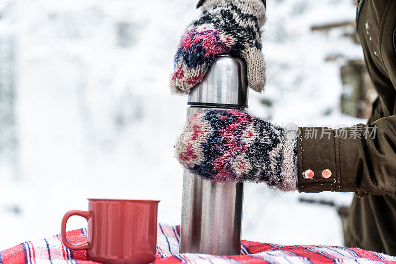 冬天的场景——格子桌布上放着马克杯和热水瓶。