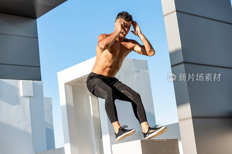适合赤膊运动员跳上增强式木箱户外建筑屋顶，家庭体重锻炼运动概念