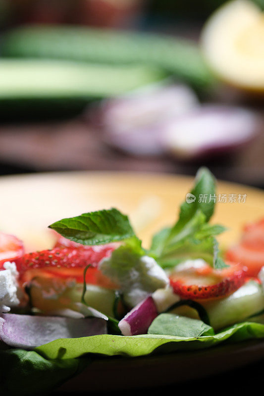 用新鲜菠菜、莴苣、草莓和羊乳酪制作健康沙拉