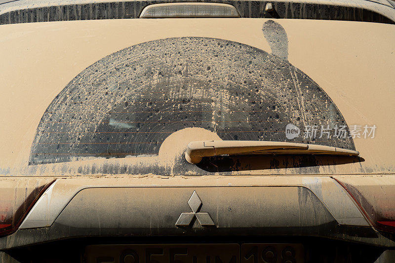 脏兮兮的后车窗上有三菱SUV车的雨刷痕迹。