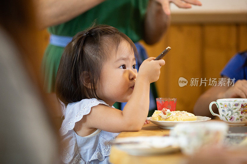 可爱的小女孩在餐桌旁