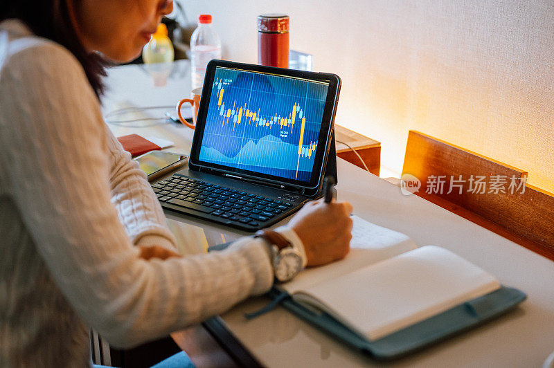 一名亚洲女商人使用笔记本电脑在酒店房间远程工作在她的商务旅行
