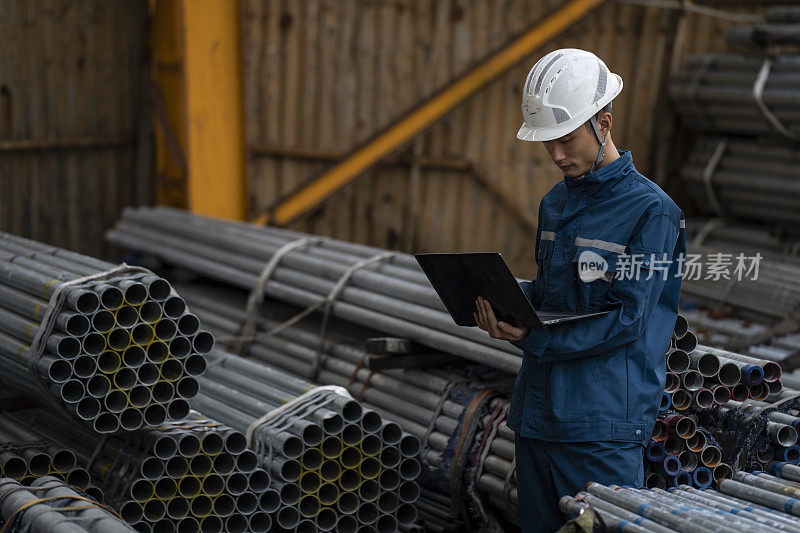 中国男性工厂工人正在用笔记本电脑清点存货