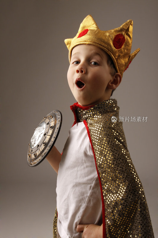 年轻的男孩穿着国王的服装戴着王冠