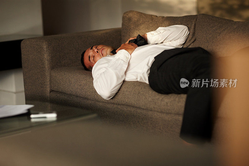 压力-疲惫的商人睡在沙发上