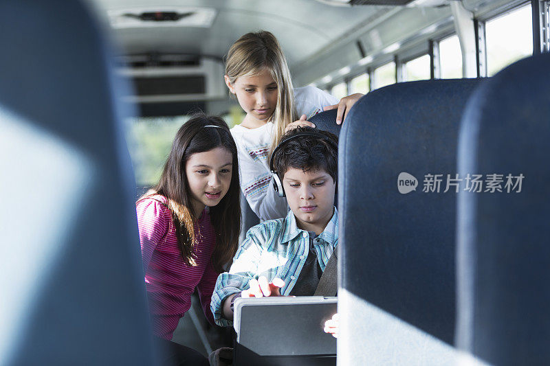 孩子们在校车上拿着平板电脑