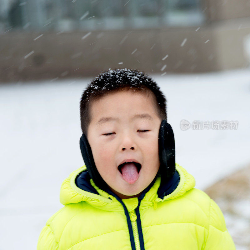 一个亚洲男孩在雪地里玩