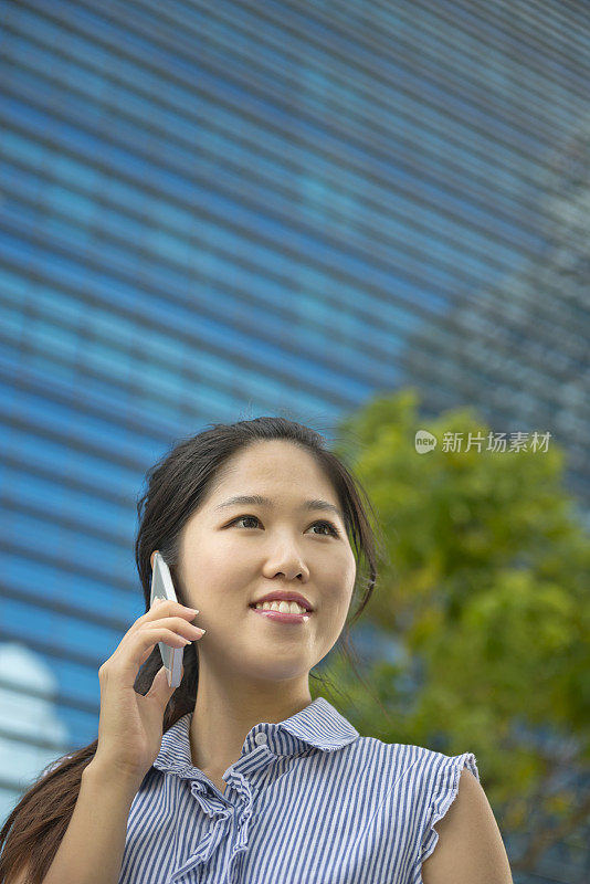 年轻的中国女人在用手机聊天