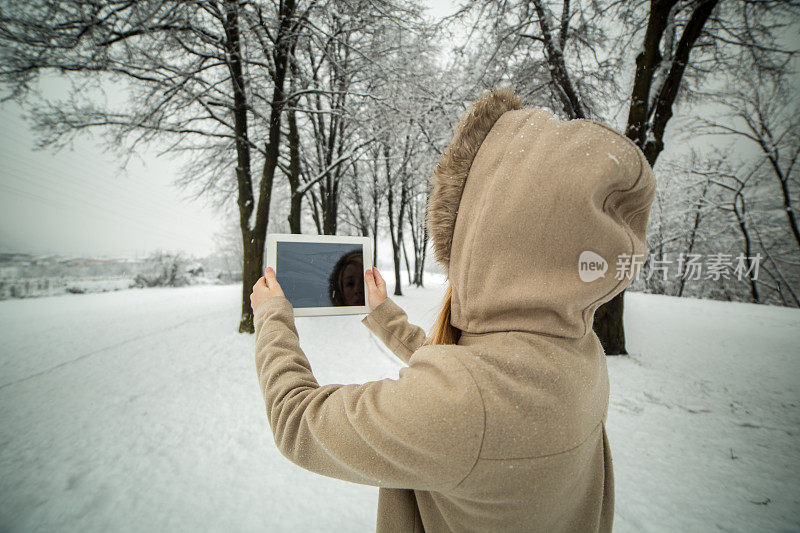 女子在公园用数码平板电脑拍照