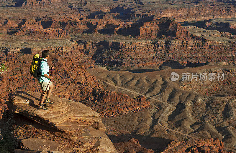 男性徒步旅行者站在岩石顶端看风景