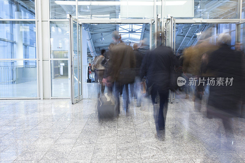 模糊的上班族穿过玻璃门