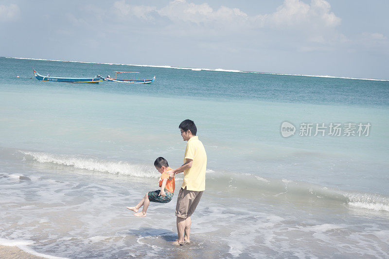 爸爸和儿子在海滩上玩