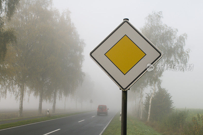 大雾弥漫的乡村道路上的让车标志