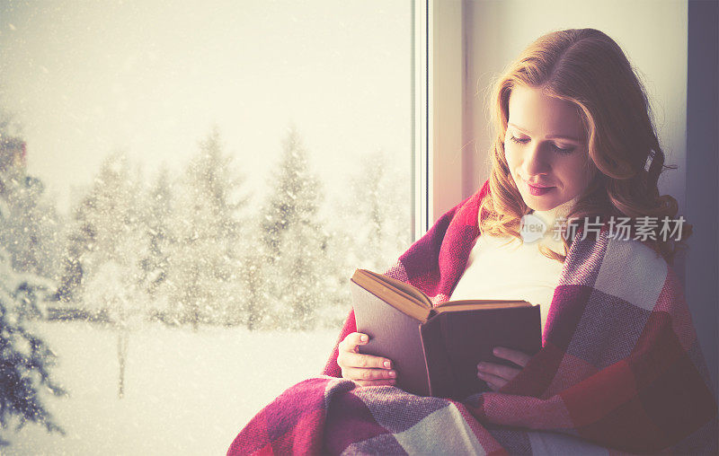 冬天里，快乐的女孩在窗边看书