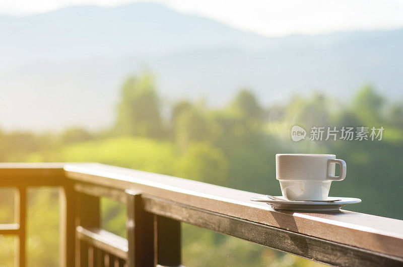 白色杯的热咖啡与自然和山脉。
