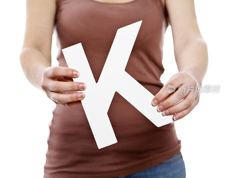 年轻女性的手拿着大剪纸字母K