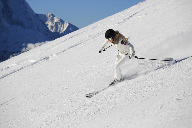 在阳光明媚的滑雪胜地滑雪的中年妇女滑雪