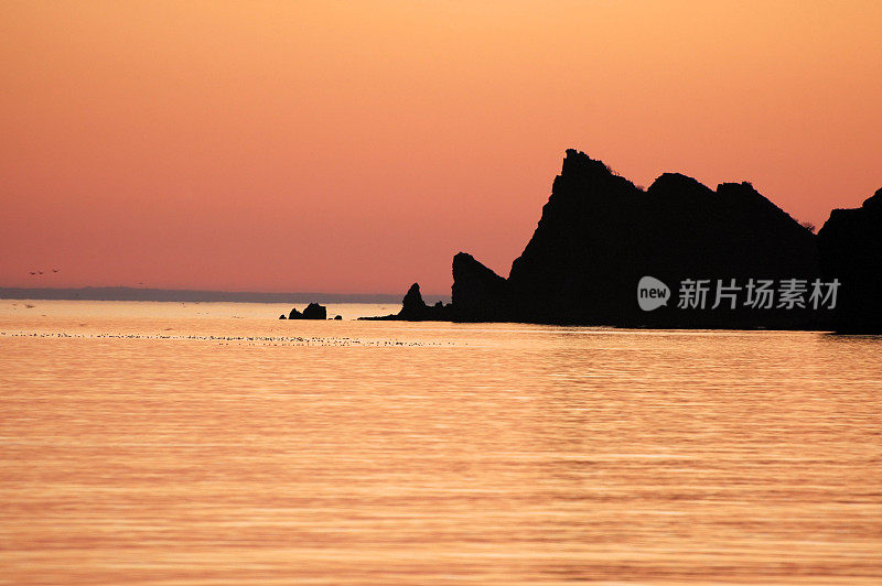 日出时看到的大海和岛屿岩石