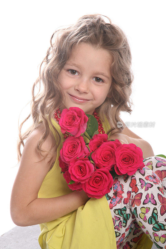 可爱的卷发女孩与玫瑰摆姿势