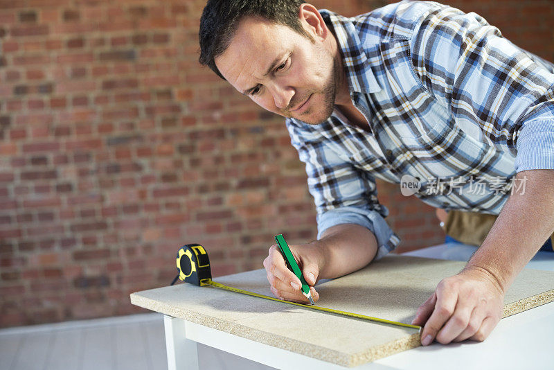 建筑工人测量木板的木材