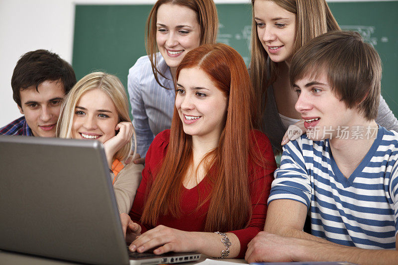 一组学生在教室使用笔记本电脑