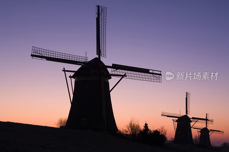 一群传统的荷兰风车后，五颜六色的日出