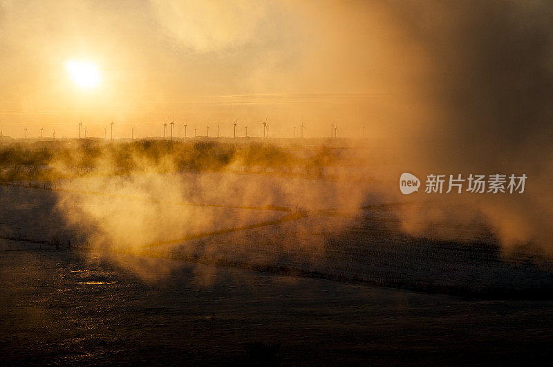 风力涡轮机在夕阳后面的云