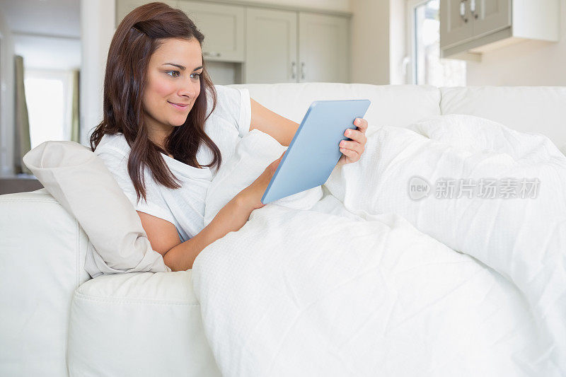 深色头发的女人正在用平板电脑放松