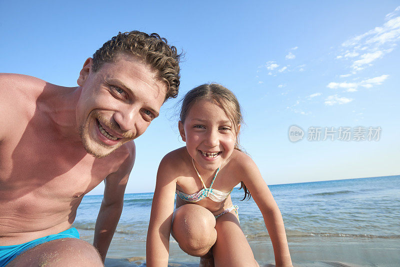 小女孩和爸爸在沙滩上玩
