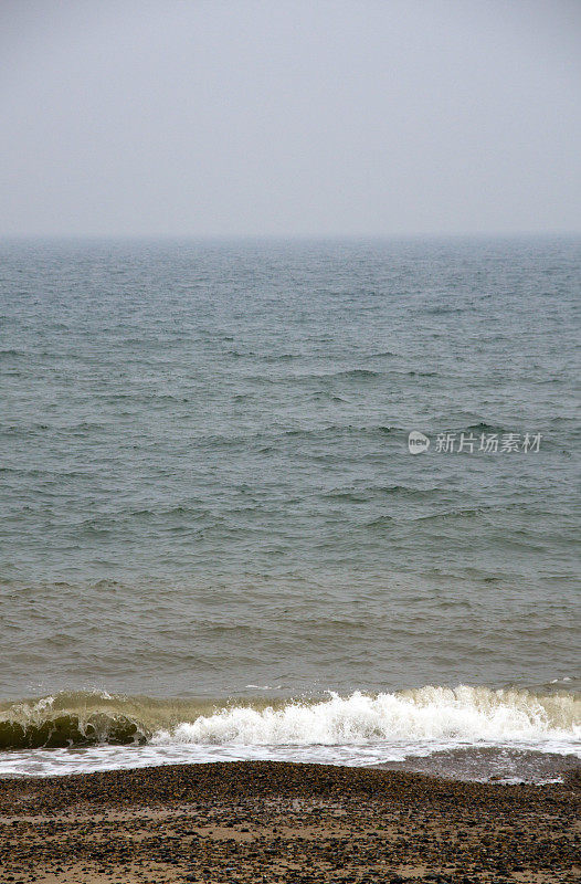海浪拍打着覆盖着石头的海滩。