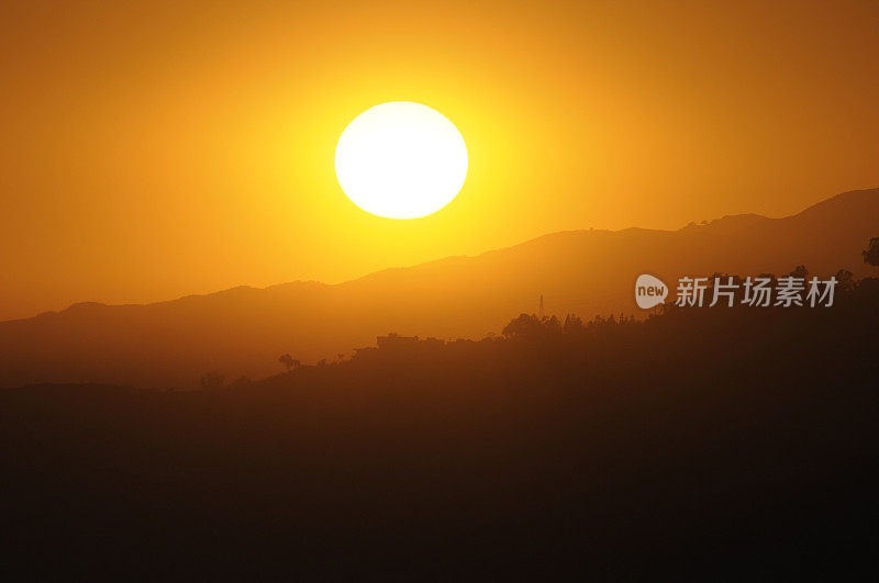 夕阳橙色的光芒透过加州的薄雾