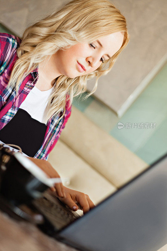 美丽的年轻女孩在咖啡馆使用笔记本电脑