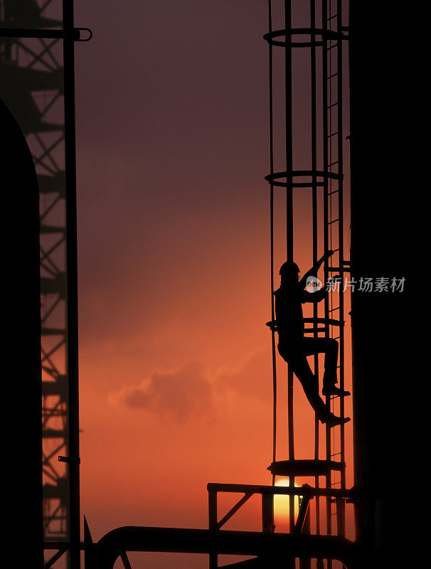 工人爬上炼油厂的梯子