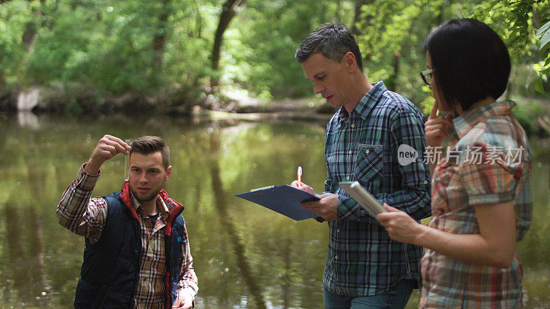 三位科学家正在探索湖中的水