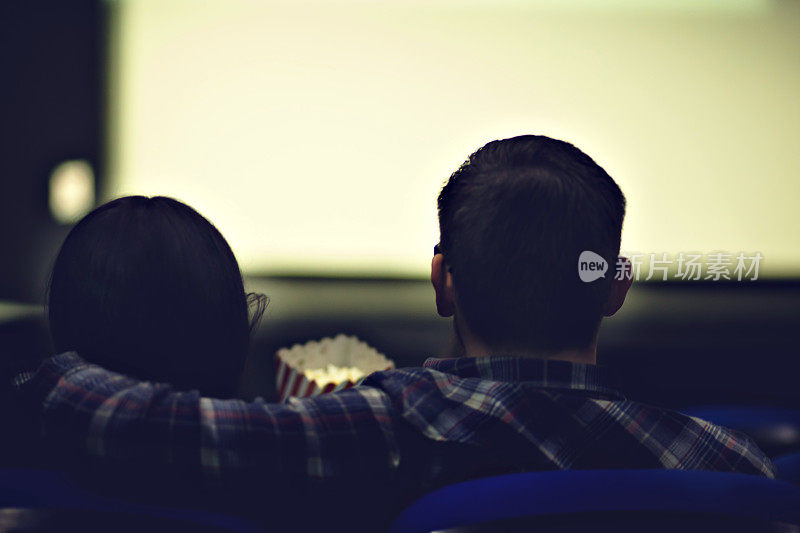年轻漂亮的女人和男朋友在电影院看电影