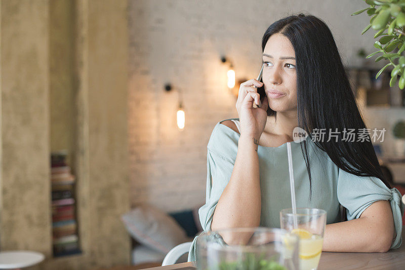 在咖啡馆里拿着手机的女人