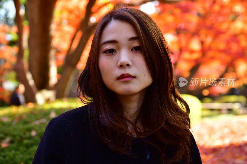 东京秋叶下的年轻日本女人肖像
