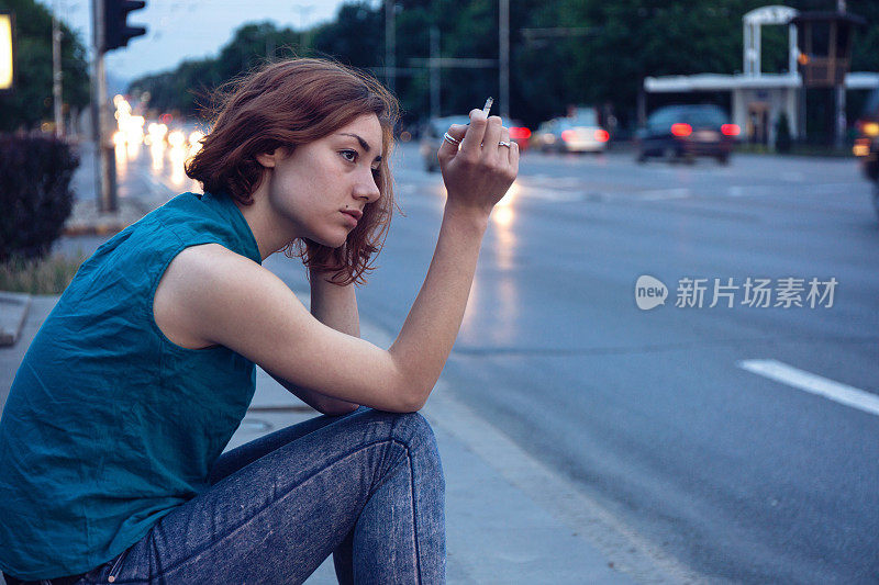 悲伤的女孩在大街上抽烟