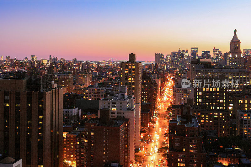 日落时分的纽约城市天际线，沿着第三大道，曼哈顿市中心的摩天大楼，维拉萨诺狭窄桥的背景和橙蓝色晴朗的天空。