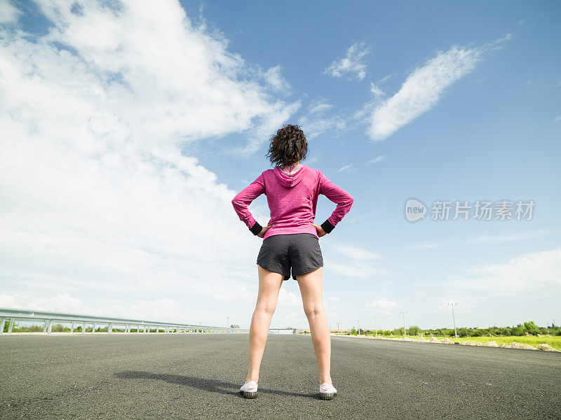 一名成年女子准备在柏油路上慢跑