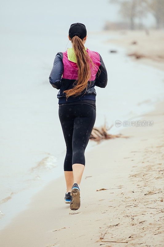 女人在下雨天的河滩上慢跑，后视镜